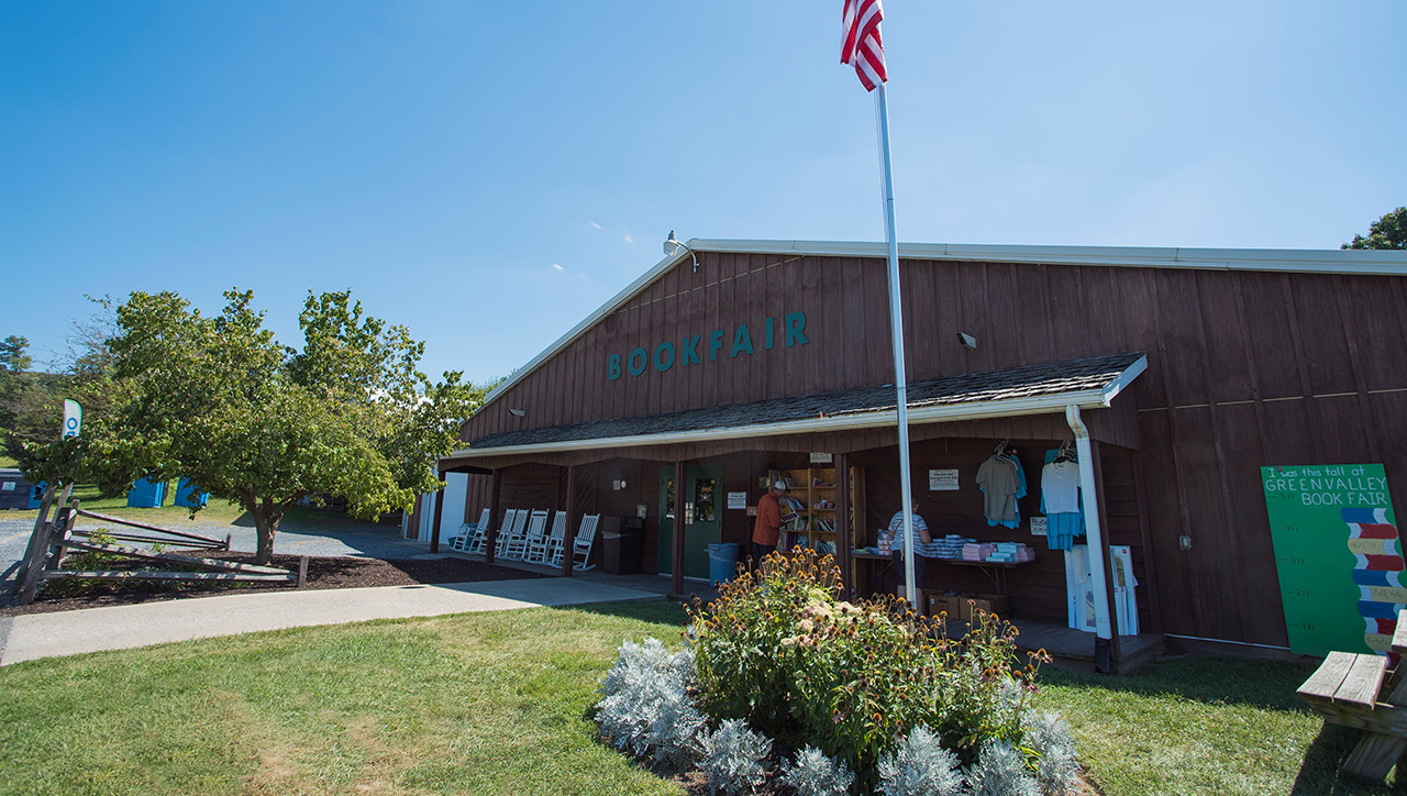 A sidewalk through some grass leads to the front entrance of Green Valley Book Fair.