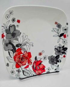 9-inch Corelle salad plate with greyscale and red flowers.